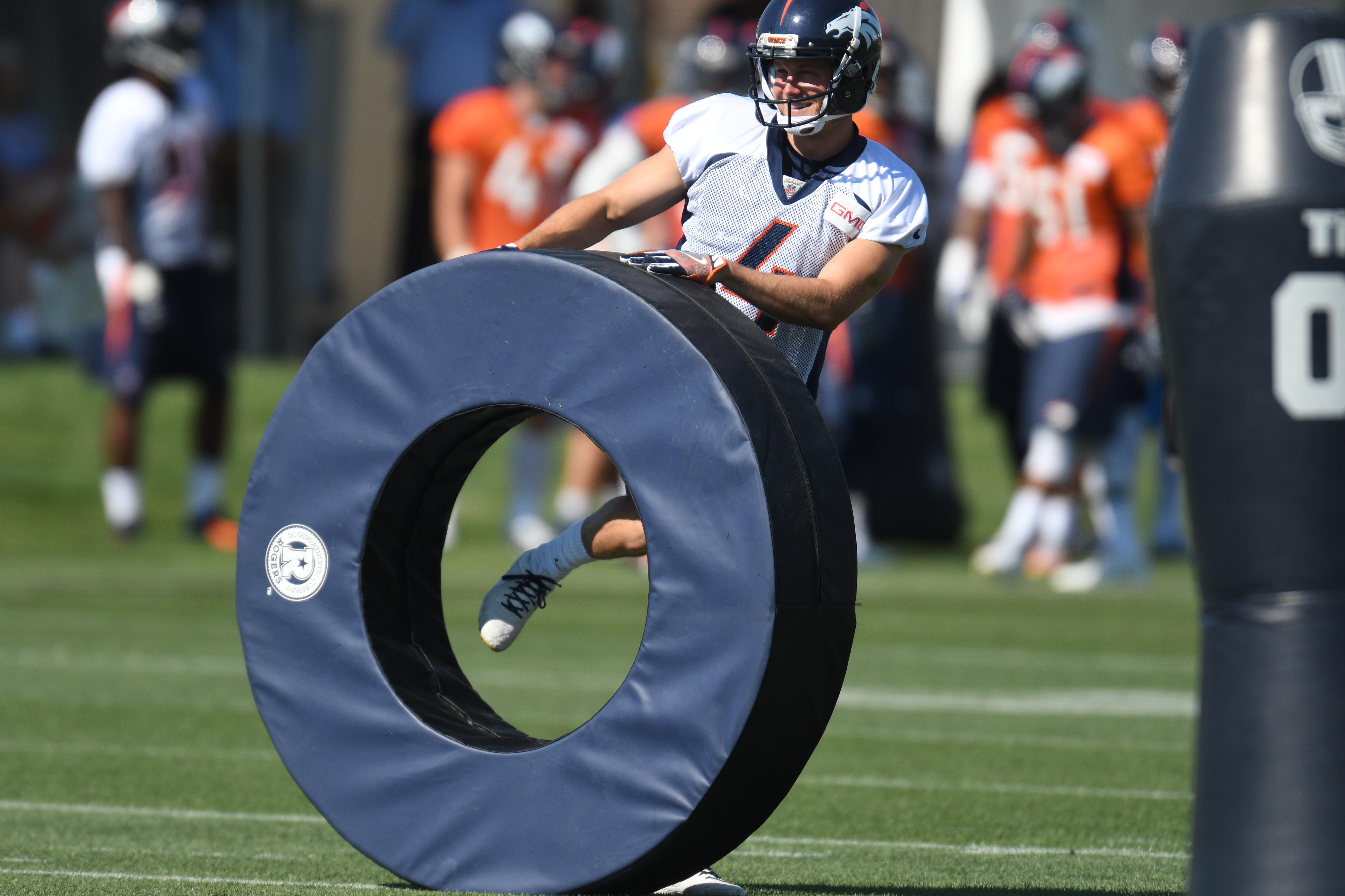 Jul 28, 2016; Englewood, CO, USA; Denver Broncos punter Britton Colquitt (4) holds a training pad during drills held at the UCHealth Training Center. Mandatory Credit: Ron Chenoy-USA TODAY Sports
