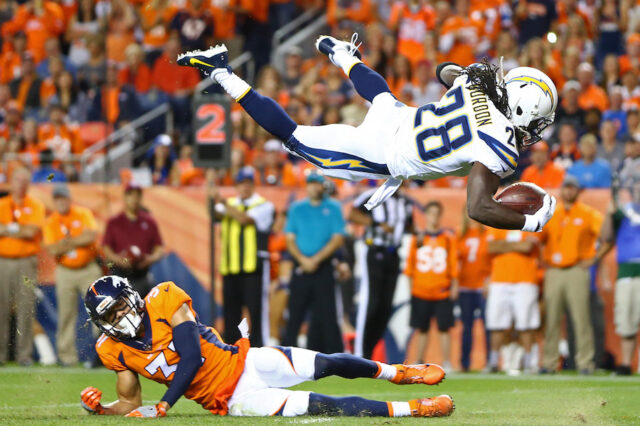 Los Angeles Chargers running back Melvin Gordon (31) leaps over Denver Broncos safety Justin Simmons (31) to score in the second quarter at Sports Authority Field.