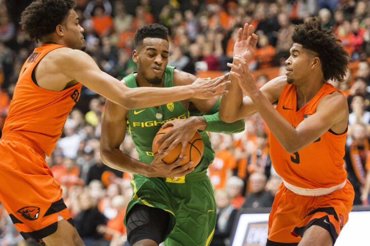 Oregon Ducks forward Troy Brown (0) drives between Oregon State Beavers guard Stephen Thompson Jr. (1) and guard Ethan Thompson (5) during the first half during a game at Gill Coliseum