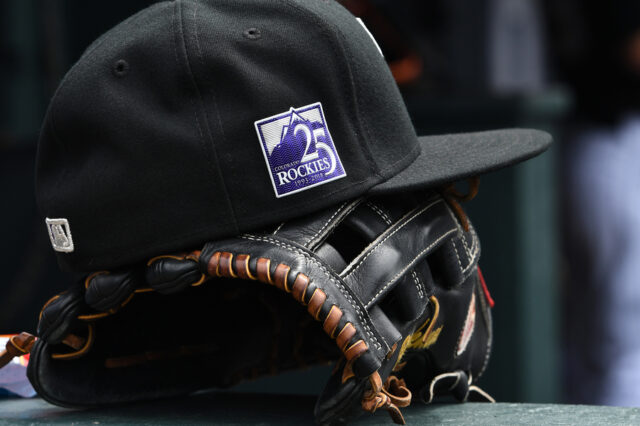 eneral view of a cap and glove for Colorado Rockies marking the twenty fifth anniversary emblem of the team during the game Los Angeles Dodgers at Coors Field. Mandatory Credit: Ron Chenoy-USA TODAY Sports