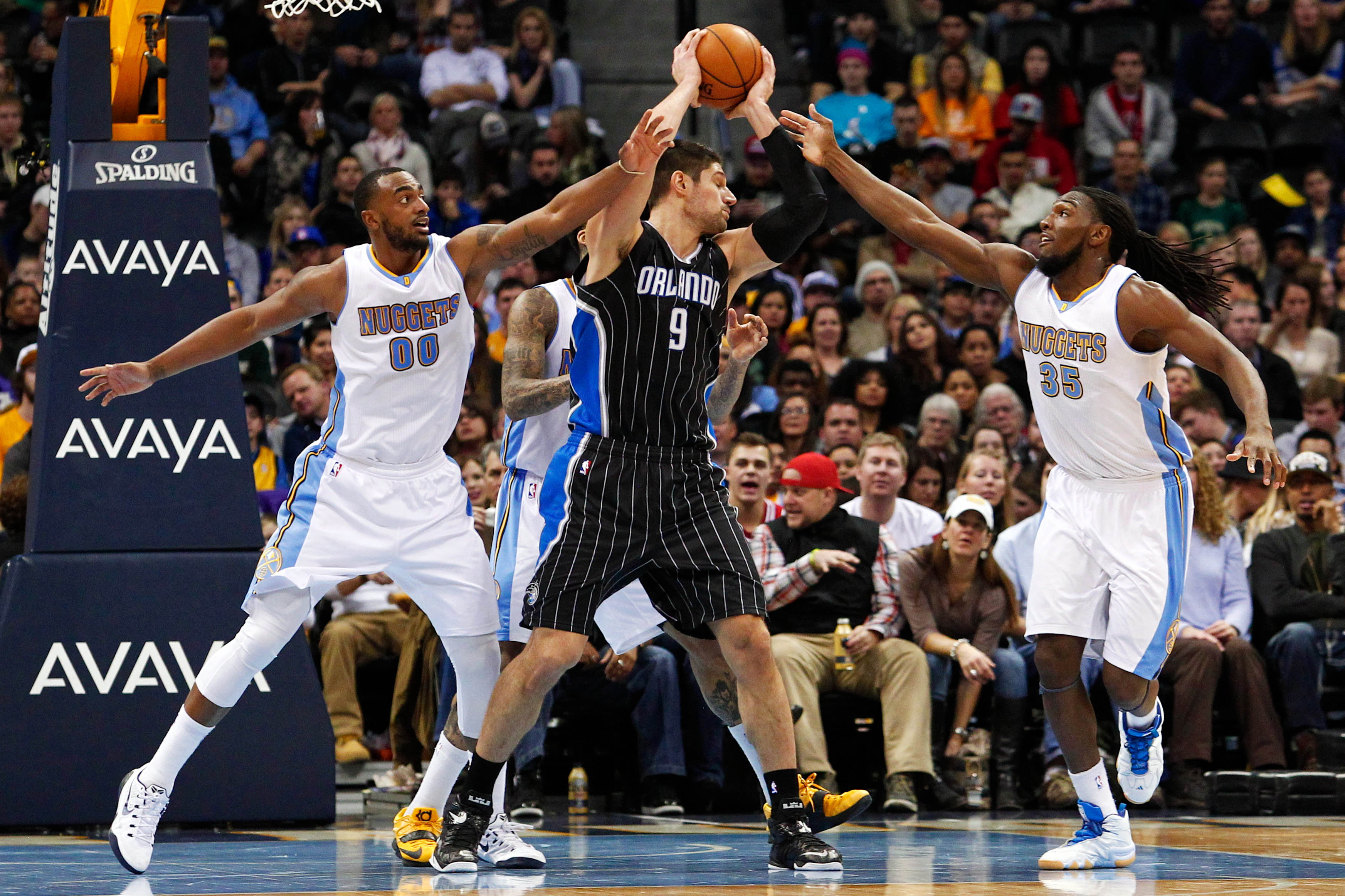 NBA: Orlando Magic at Denver Nuggets Orlando Magic center Nikola Vucevic (9) controls the ball against Denver Nuggets forward Darrell Arthur (00) and forward Kenneth Faried (35) in the second quarter at Pepsi Center.