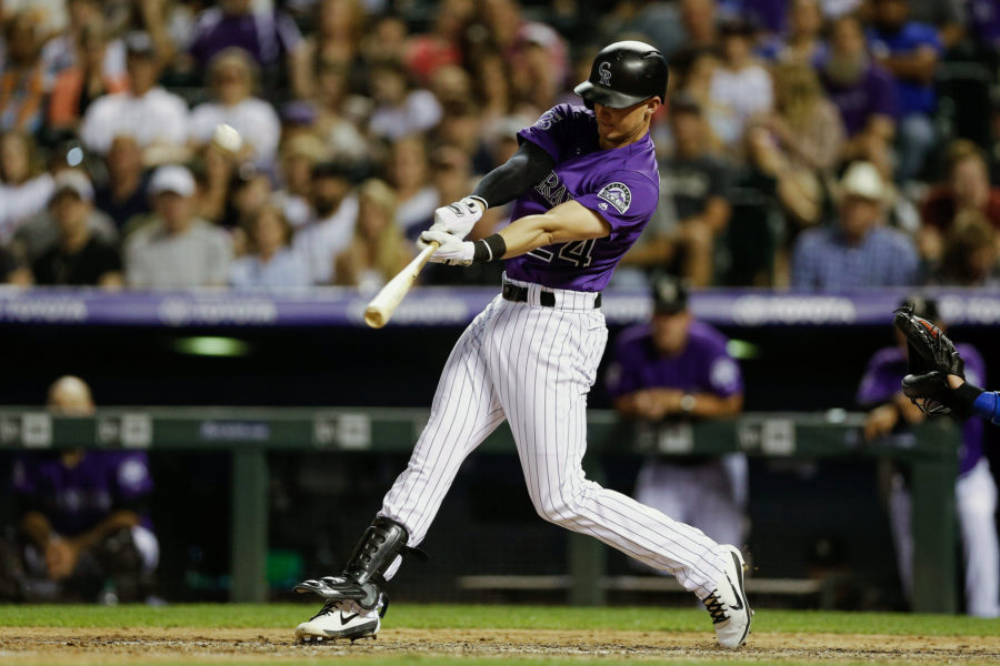 Colorado Rockies third baseman Ryan McMahon (24) hits a two run home run in the seventh inning against the Los Angeles Dodgers at Coors Field.
