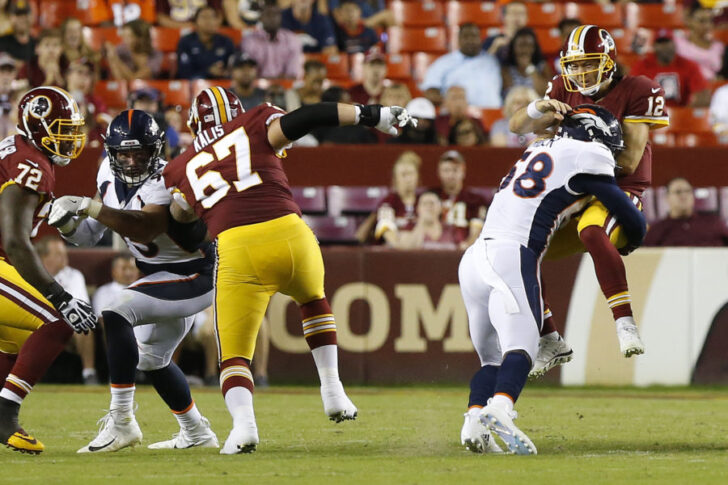 Washington Redskins quarterback Colt McCoy (12) is hit by Denver Broncos linebacker Von Miller (58) while passing the ball in the second quarter at FedEx Field.