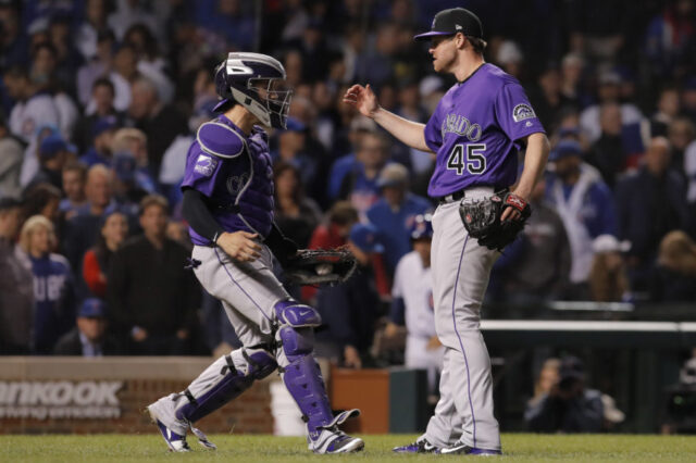 Colorado Rockies players Tony Wolters (left) and Scott Oberg (45) celebrate after defeating the Chicago Cubs in the 2018 National League wild card playoff baseball game at Wrigley Field.