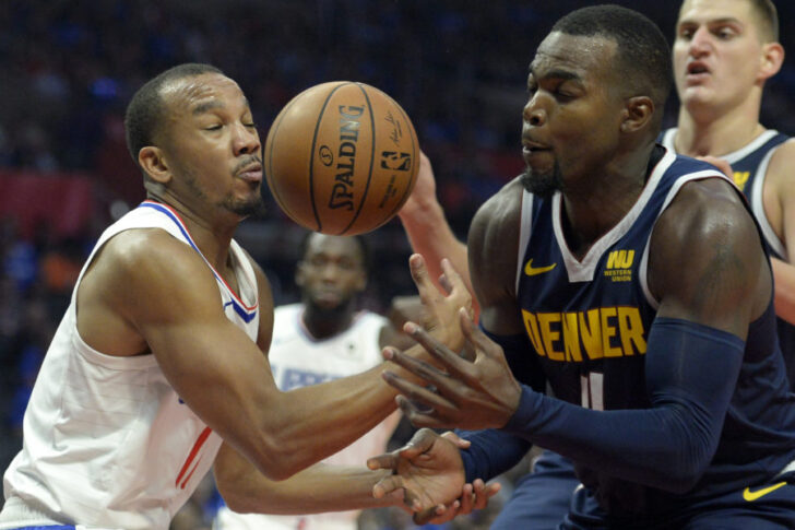 LA Clippers guard Avery Bradley (11) and Denver Nuggets forward Paul Millsap (4) battle for a loose ball during the third quarter at Staples Center.