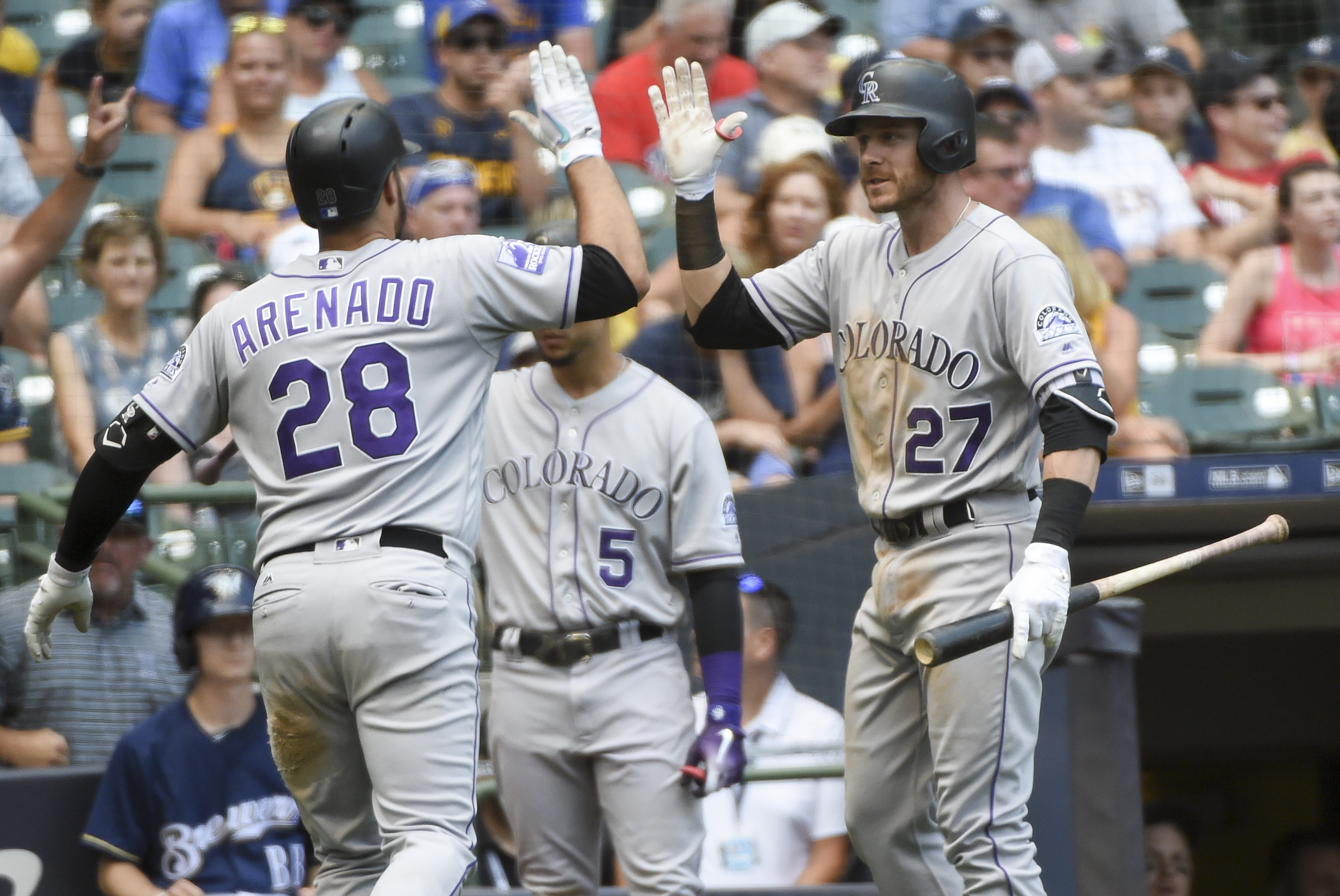 Colorado Rockies third baseman Nolan Arenado (28) is greeted by shortstop Trevor Story (27) after hitting a solo home run in the eleventh inning against the Milwaukee Brewers at Miller Park.