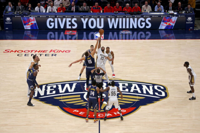 Denver Nuggets center Nikola Jokic (15) jumps with New Orleans Pelicans forward Anthony Davis (23) to start the game at the Smoothie King Center.