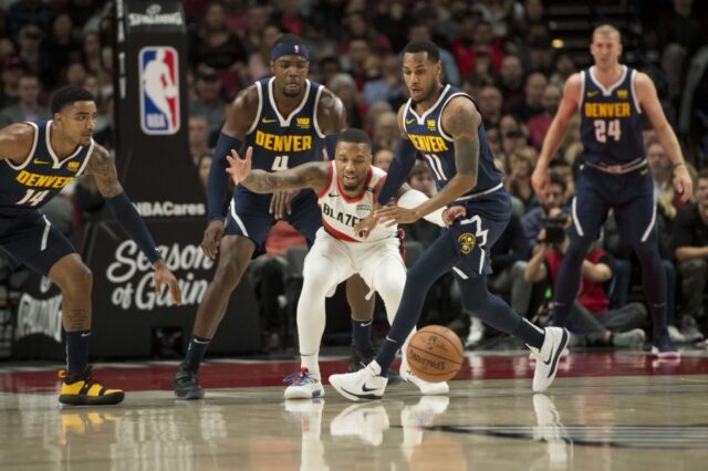 Portland Trail Blazers guard Damian Lillard (0) loses control of the basketball as he is guarded by Denver Nuggets guard Monte Morris (11) during the first half at Moda Center.