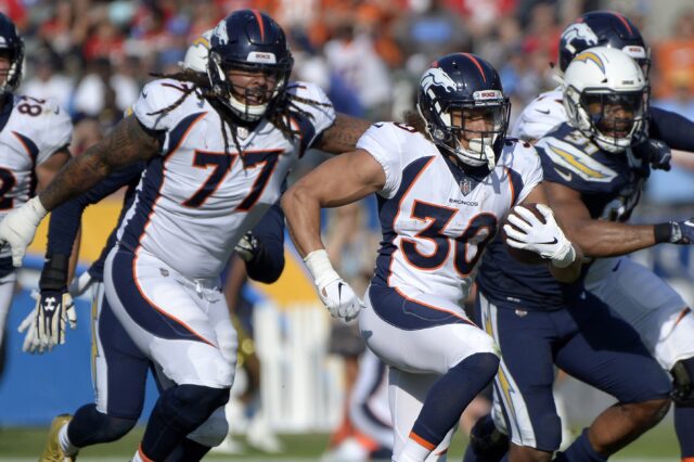 Phillip Lindsay runs away from defenders. Credit: Jake Roth, USA TODAY Sports.