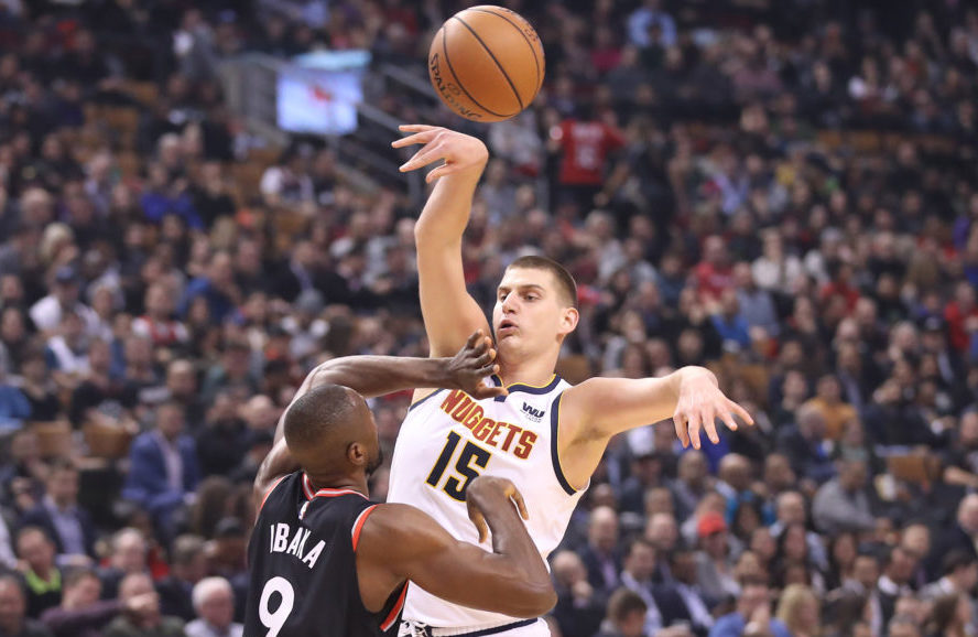 Denver Nuggets center Nikola Jokic (15) passes the ball under defensive coverage by Toronto Raptors forward Serge Ibaka (9) in the first quarter at Scotiabank Arena.