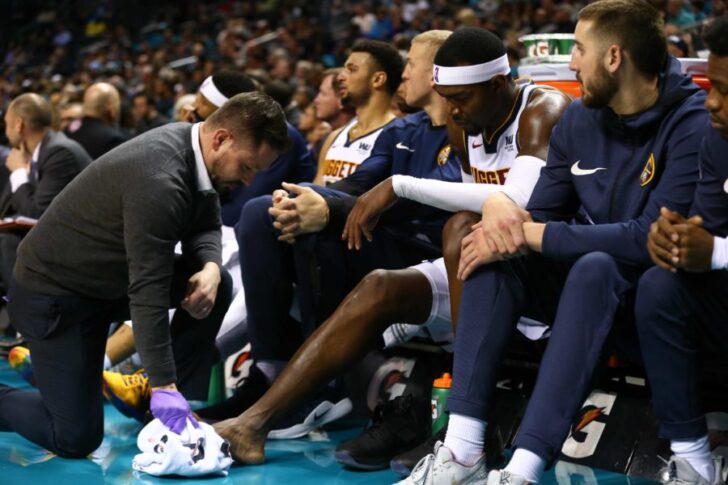 Denver Nuggets forward Paul Millsap (4) gets looked at by a trainer on the bench after being stepped on during the game against the Charlotte Hornets at Spectrum Center.
