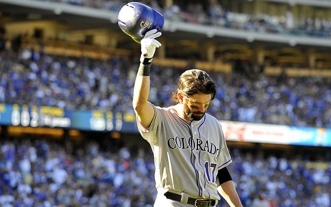 player raises batting helmet