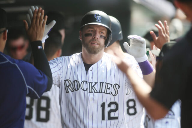 Colorado Rockies first baseman Mark Reynolds (12) celebrates with teammates in the dugout after hitting a two run home run during the sixth inning against the Pittsburgh Pirates at Coors Field.