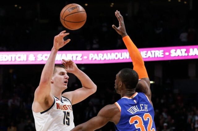 Denver Nuggets center Nikola Jokic (15) passes the ball over New York Knicks forward Noah Vonleh (32) in the first quarter at the Pepsi Center.