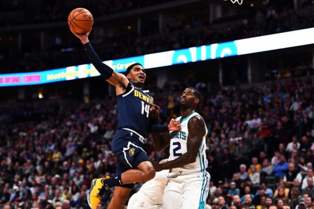 Denver Nuggets guard Gary Harris (14) attempts a shot over Charlotte Hornets forward Marvin Williams (2) in the second quarter at the Pepsi Center.
