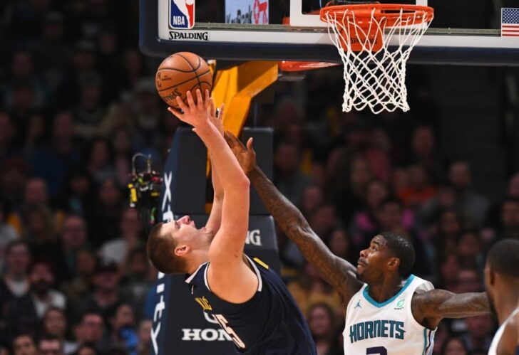 Charlotte Hornets forward Marvin Williams (2) reaches for the ball over Denver Nuggets center Nikola Jokic (15) in the second half at the Pepsi Center.