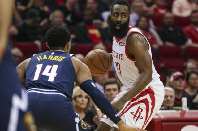 Houston Rockets guard James Harden (13) dribbles the ball against Denver Nuggets guard Gary Harris (14) during the first quarter at Toyota Center.