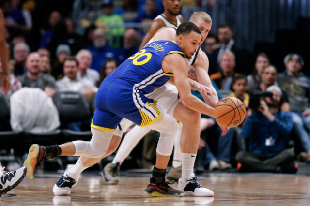 Golden State Warriors guard Stephen Curry (30) and Denver Nuggets forward Mason Plumlee (24) battle for the ball in the second quarter at the Pepsi Center.
