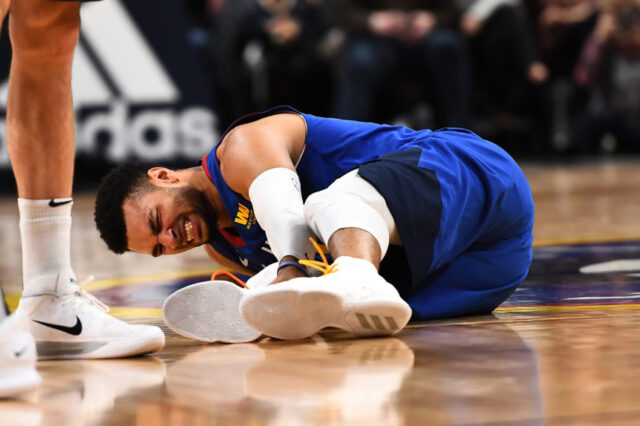 Denver Nuggets guard Jamal Murray (27) lays injured on the court in the fourth quarter against the San Antonio Spurs at the Pepsi Center.