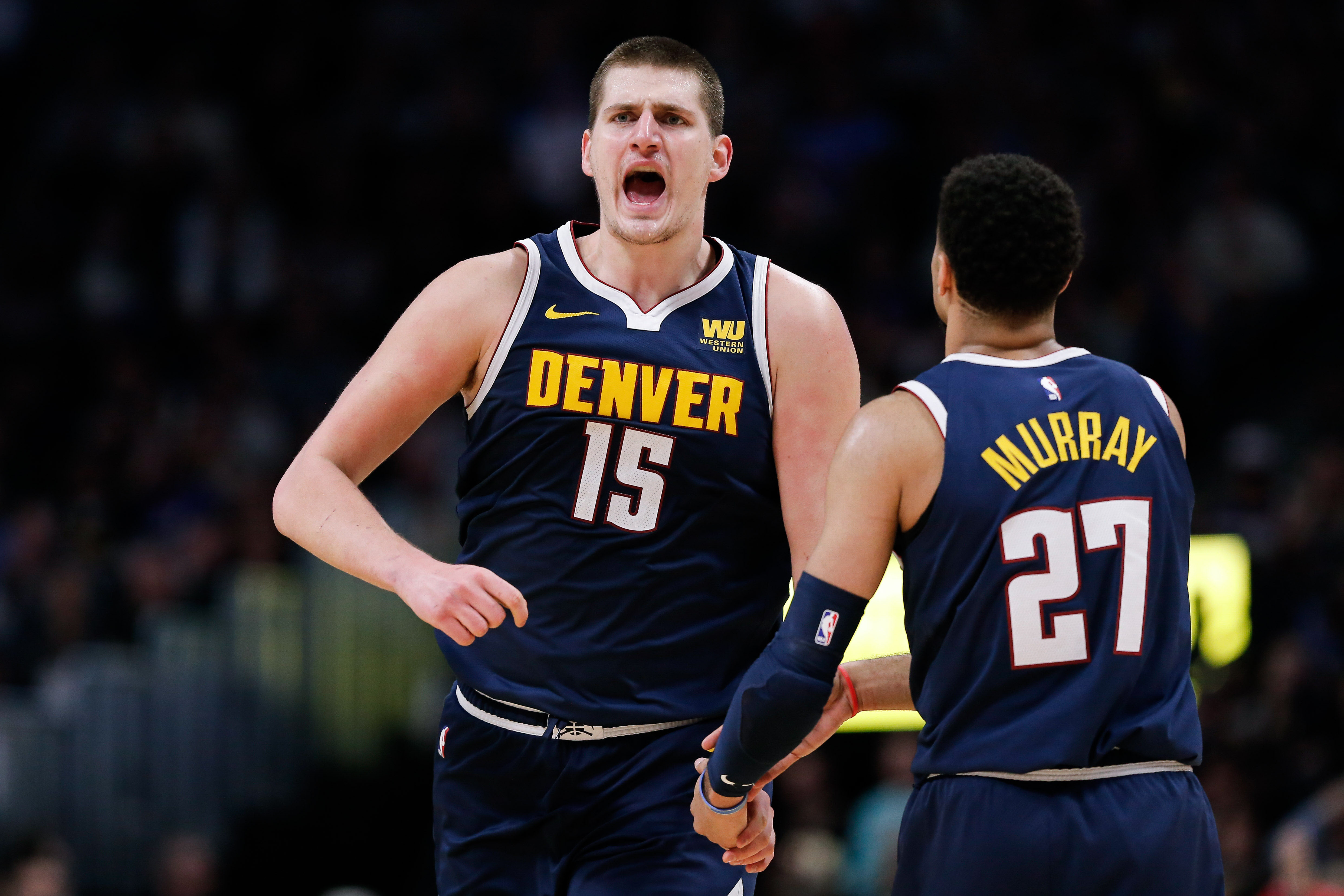 Denver Nuggets center Nikola Jokic (15) reacts with guard Jamal Murray (27) after a play in the third quarter against the Los Angeles Clippers at the Pepsi Center.