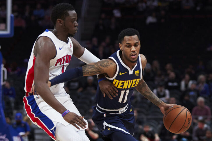 Denver Nuggets guard Monte Morris (11) dribbles the ball defended by Detroit Pistons guard Reggie Jackson (1) in the first half at Little Caesars Arena.