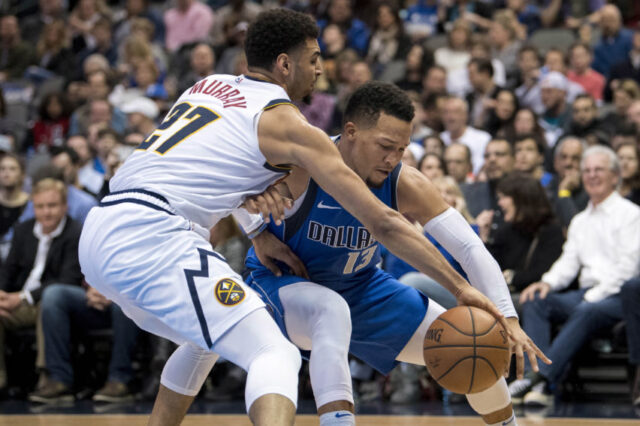 Denver Nuggets guard Jamal Murray (27) and Dallas Mavericks guard Jalen Brunson (13) fight for the loose ball during second quarter at the American Airlines Center.