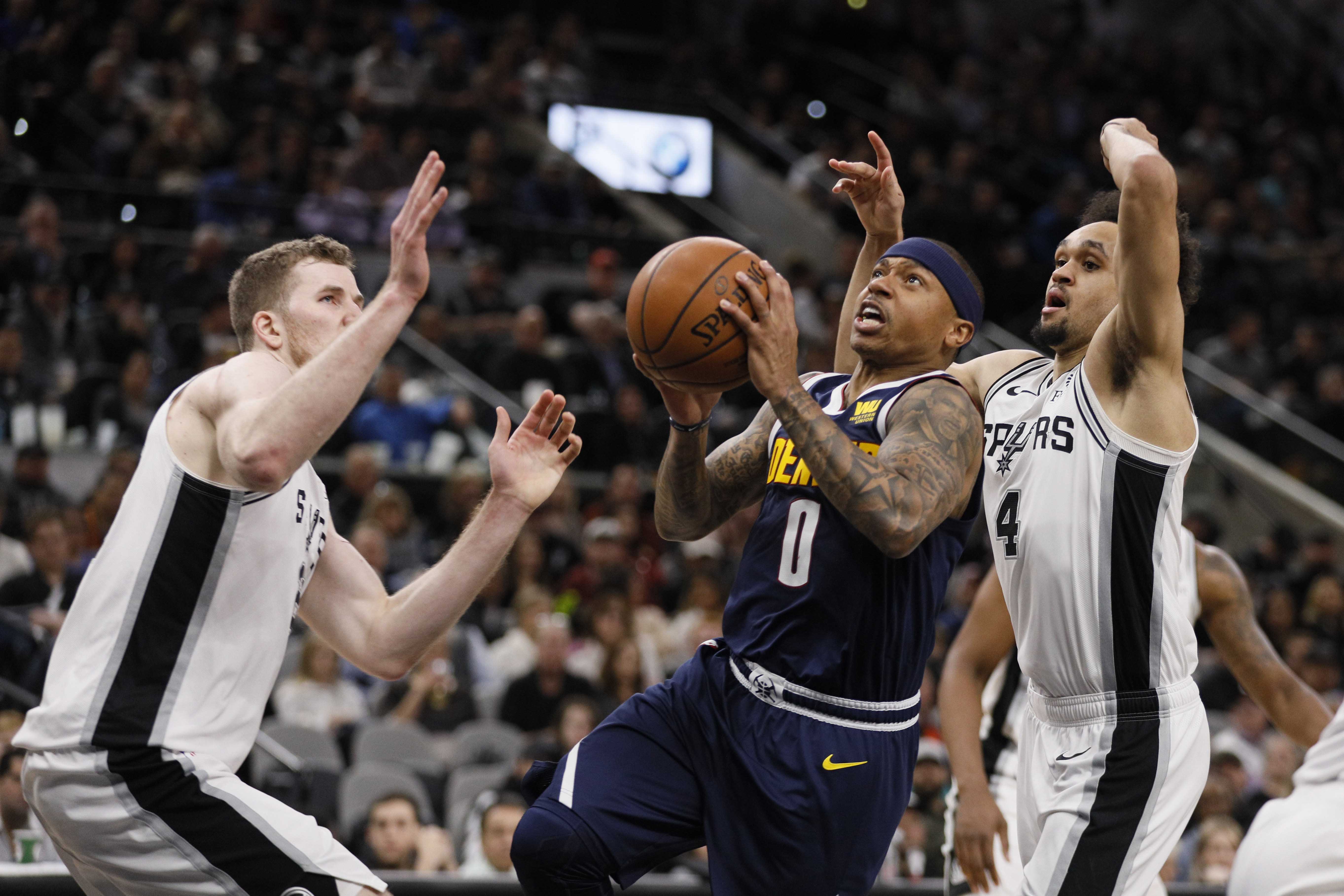 NBA: Denver Nuggets at San Antonio Spurs Denver Nuggets point guard Isaiah Thomas (0) drives to the basket as San Antonio Spurs point guard Derrick White (4) and Jakob Poeltl (left) defend during the first half at AT&T Center.