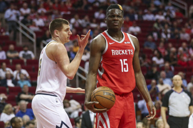 Denver Nuggets center Nikola Jokic (15) and Houston Rockets center Clint Capela (15) react after a play during the first quarter at Toyota Center.