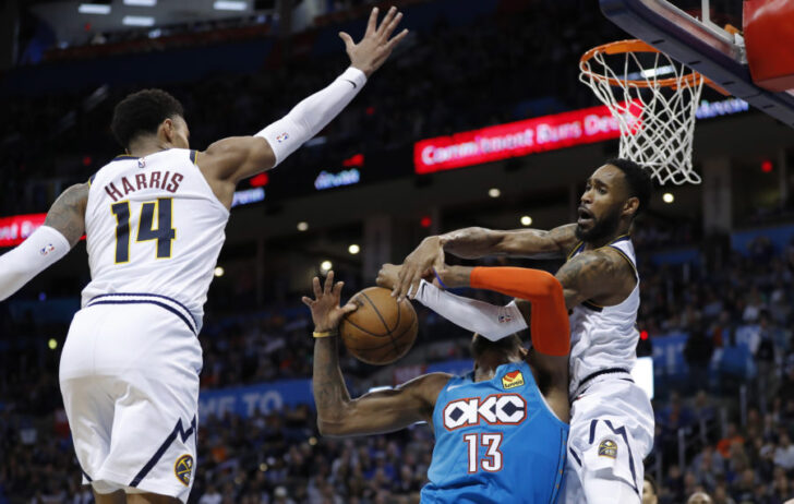 Oklahoma City, OK, USA; Oklahoma City Thunder forward Paul George (13) is fouled by Denver Nuggets guard Will Barton (5) as guard Gary Harris (14) defends during the second half at Chesapeake Energy Arena. Denver won 115-105.