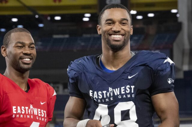 Justin Hollins (right) receives an award as the defensive MVP of the East-West Shrine Game.