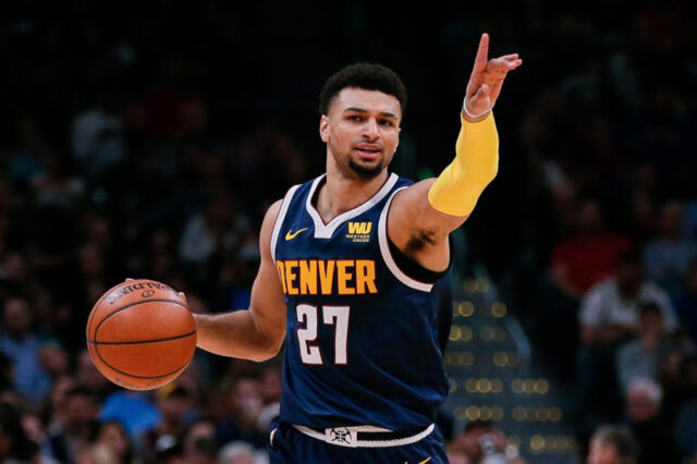 Denver Nuggets guard Jamal Murray (27) motions as he dribbles the ball up court in the second quarter against the San Antonio Spurs at the Pepsi Center.