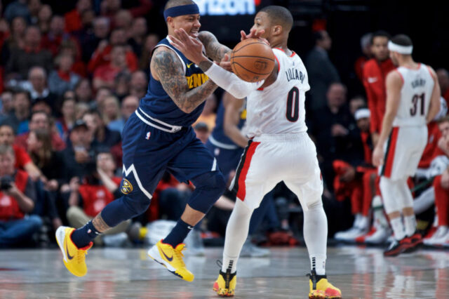 Denver Nuggets guard Isaiah Thomas (0) steals the ball from Portland Trail Blazers guard Damian Lillard (0) during the first quarter at the Moda Center.