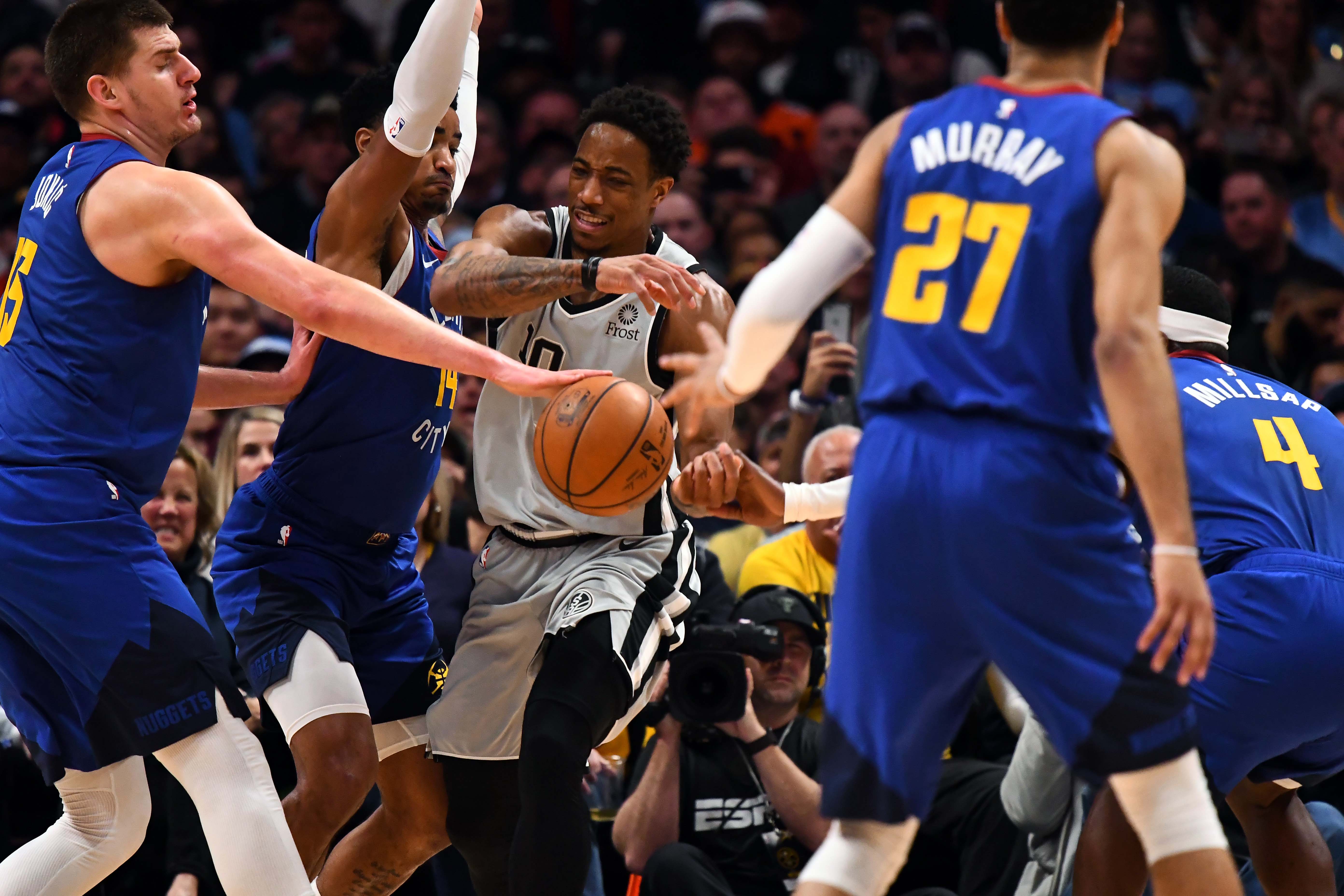 NBA: Playoffs-San Antonio Spurs at Denver Nuggets Denver Nuggets center Nikola Jokic (15) and forward Paul Millsap (4) and guard Gary Harris (14) defend San Antonio Spurs guard DeMar DeRozan (10) in the second quarter of the first round of the 2019 NBA Playoffs at Pepsi Center.