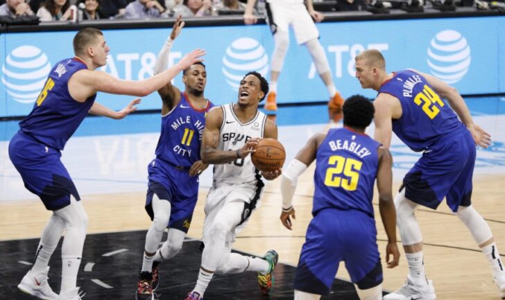 San Antonio Spurs shooting guard DeMar DeRozan (10) drives for the basket between Denver Nuggets point guard Monte Morris (11) and Malik Beasley (25) in game four of the first round of the 2019 NBA Playoffs at AT&T Center.