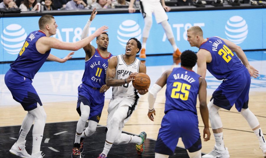 San Antonio Spurs shooting guard DeMar DeRozan (10) drives for the basket between Denver Nuggets point guard Monte Morris (11) and Malik Beasley (25) in game four of the first round of the 2019 NBA Playoffs at AT&T Center.
