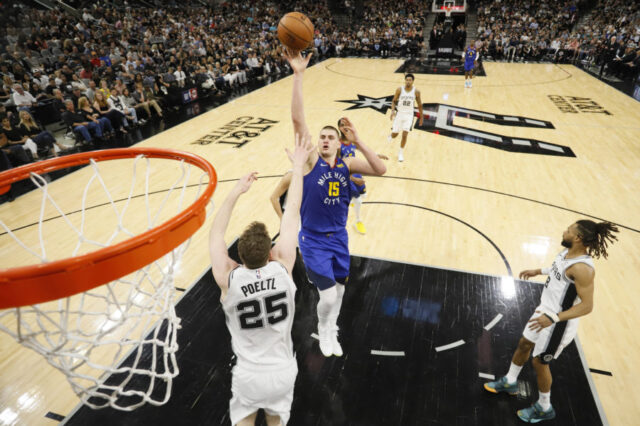 Denver Nuggets center Nikola Jokic (15) shoots the ball over San Antonio Spurs center Jakob Poeltl (25) in game four of the first round of the 2019 NBA Playoffs at AT&T Center.