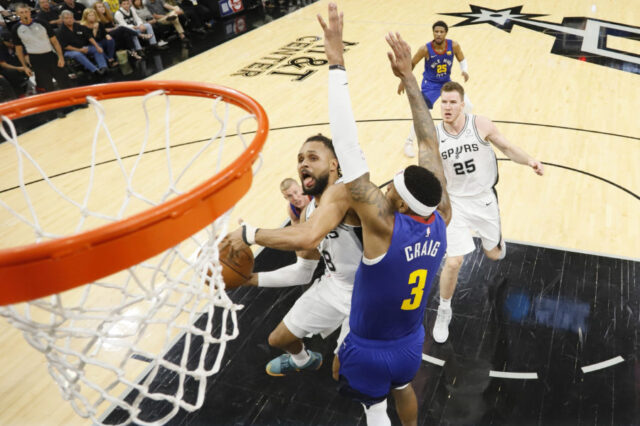 San Antonio Spurs point guard Patty Mills (8) shoots the ball under pressure from Denver Nuggets small forward Torrey Craig (3) in game four of the first round of the 2019 NBA Playoffs at AT&T Center.