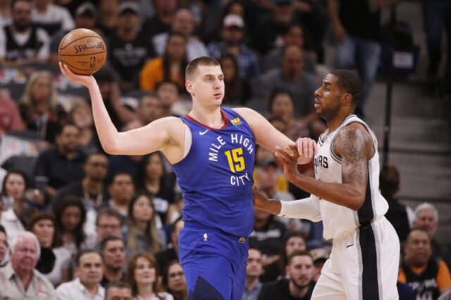 Denver Nuggets center Nikola Jokic (15) looks to pass against San Antonio Spurs power forward LaMarcus Aldridge (right) in game six of the first round of the 2019 NBA Playoffs at AT&T Center