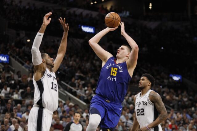Denver Nuggets center Nikola Jokic (15) shoots the ball over San Antonio Spurs power forward LaMarcus Aldridge (12) in game six of the first round of the 2019 NBA Playoffs at AT&T Center.