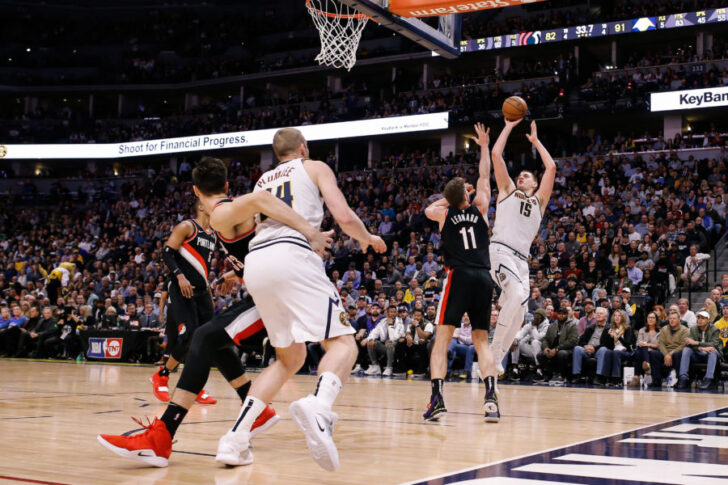 Denver Nuggets center Nikola Jokic (15) shoots the ball over Portland Trail Blazers forward Meyers Leonard (11) as forward Zach Collins (33) and forward Mason Plumlee (24) battle for position in the third quarter in game one of the second round of the 2019 NBA Playoffs at the Pepsi Center.