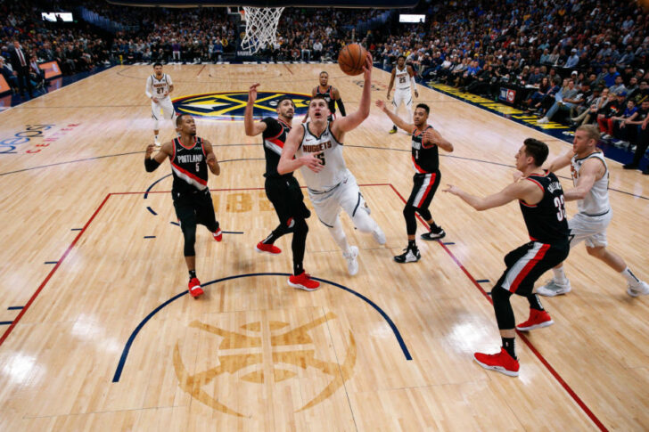 Denver Nuggets center Nikola Jokic (15) shoots the ball past Portland Trail Blazers guard Rodney Hood (5), center Enes Kanter (00), guard CJ McCollum (3) and forward Zach Collins (33) in front of Nuggets forward Mason Plumlee (24) in the third quarter in game one of the second round of the 2019 NBA Playoffs at the Pepsi Center.