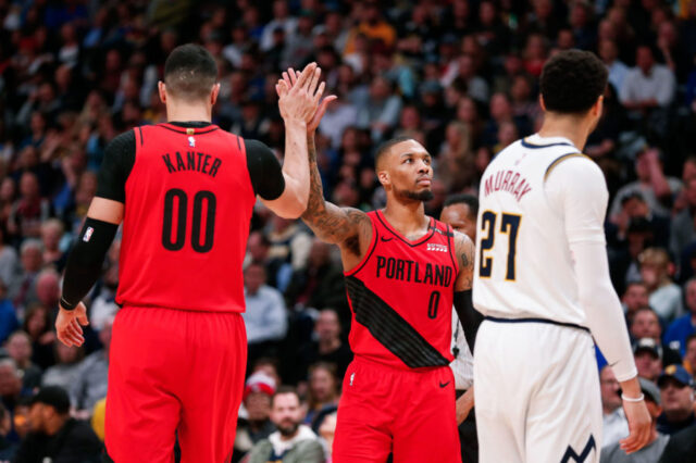 Portland Trail Blazers center Enes Kanter (00) and guard Damian Lillard (0) celebrate in front of Denver Nuggets guard Jamal Murray (27) in the second quarter in game two of the second round of the 2019 NBA Playoffs at the Pepsi Center.