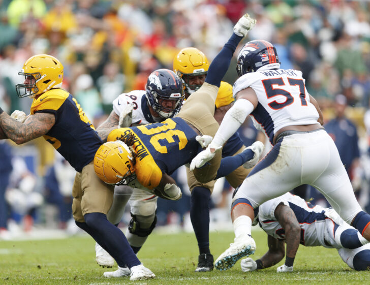 Green Bay Packers running back Jamaal Williams (30) is tackled by Denver Broncos defensive end Adam Gotsis (99) and defensive end DeMarcus Walker (57) during the fourth quarter at Lambeau Field.