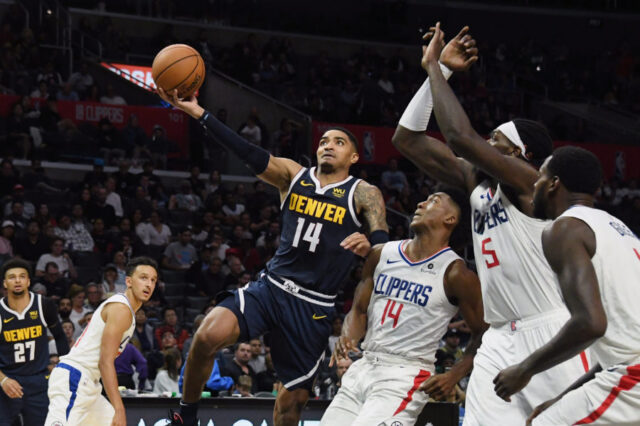 Denver Nuggets guard Gary Harris (14) drives against LA Clippers guard Terance Mann (14) and forward Montrezl Harrell (5) and forward JaMychal Green (right) during the second half at Staples Center.
