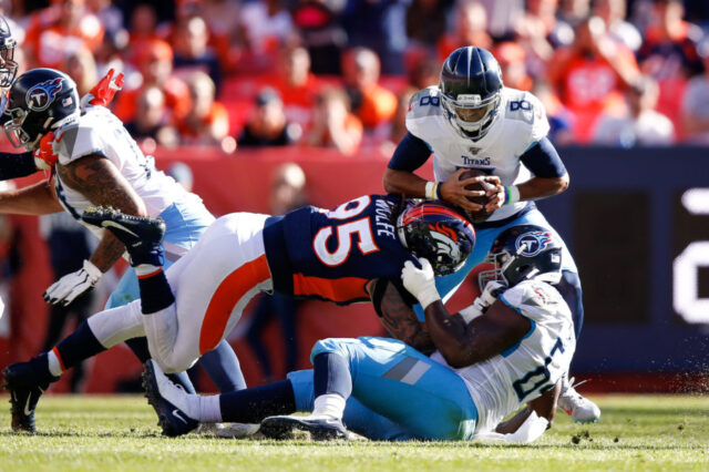 Tennessee Titans quarterback Marcus Mariota (8) is sacked by Denver Broncos defensive end Derek Wolfe (95) as guard Nate Davis (64) defends in the second quarter at Empower Field at Mile High.