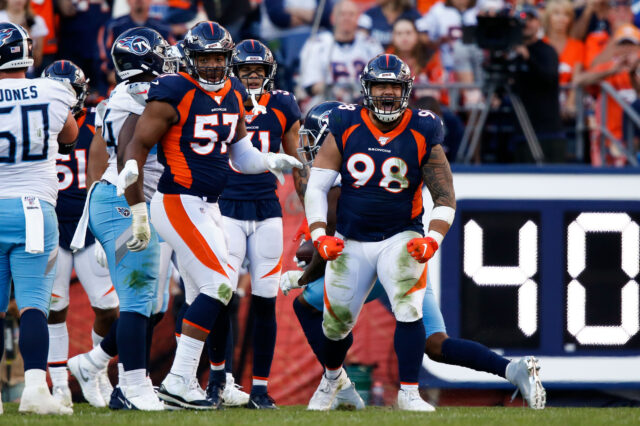 Denver Broncos nose tackle Mike Purcell (98) reacts after a play as defensive end DeMarcus Walker (57) looks on in the fourth quarter against the Tennessee Titans at Empower Field at Mile High.