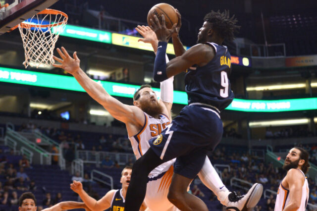 Denver Nuggets forward Jerami Grant (9) is fouled driving to the basket by Phoenix Suns center Aron Baynes (46) during the second half at Talking Stick Resort Arena.