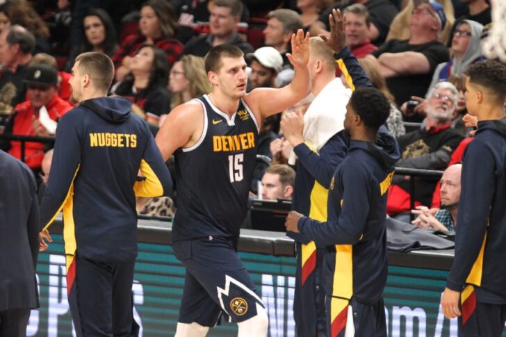 Denver Nuggets center Nikola Jokic (15) high-fives teammates after scoring against the Portland Trail Blazers during a timeout in the second half at Moda Center.
