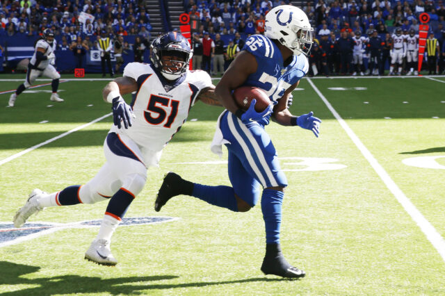 Indianapolis Colts running back Marlon Mack (25) runs away from Denver Broncos linebacker Todd Davis (51) during the first quarter at Lucas Oil Stadium.