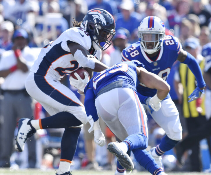 Orchard Park, NY, USA; Denver Broncos running back Jamaal Charles (28) looks to avoid a tackle by Buffalo Bills strong safety Micah Hyde (23) and cornerback E.J. Gaines (28) during the third quarter of a game at New Era Field.